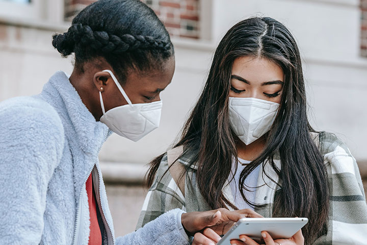 Gesundheit aus dem Internet Zwei Personen sind über ein Smartphone gebeugt.